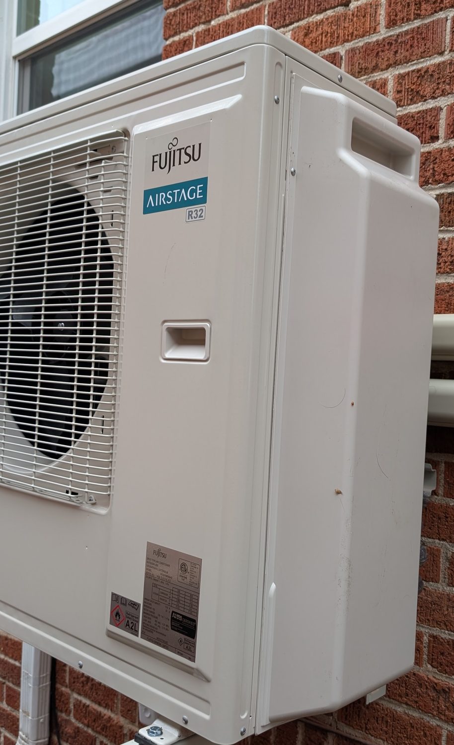 Clean outdoor heat pump condenser installation on a home exterior