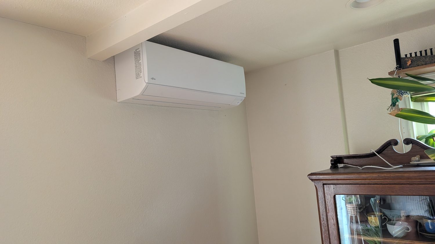 Ductless mini-split head mounted high on an interior wall