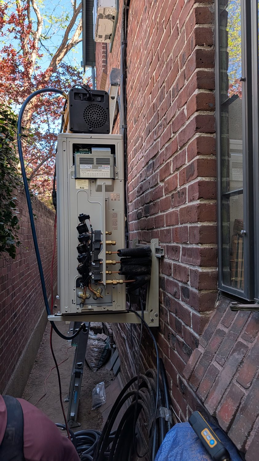 Neatly installed outdoor mini-split line sets on a brick exterior