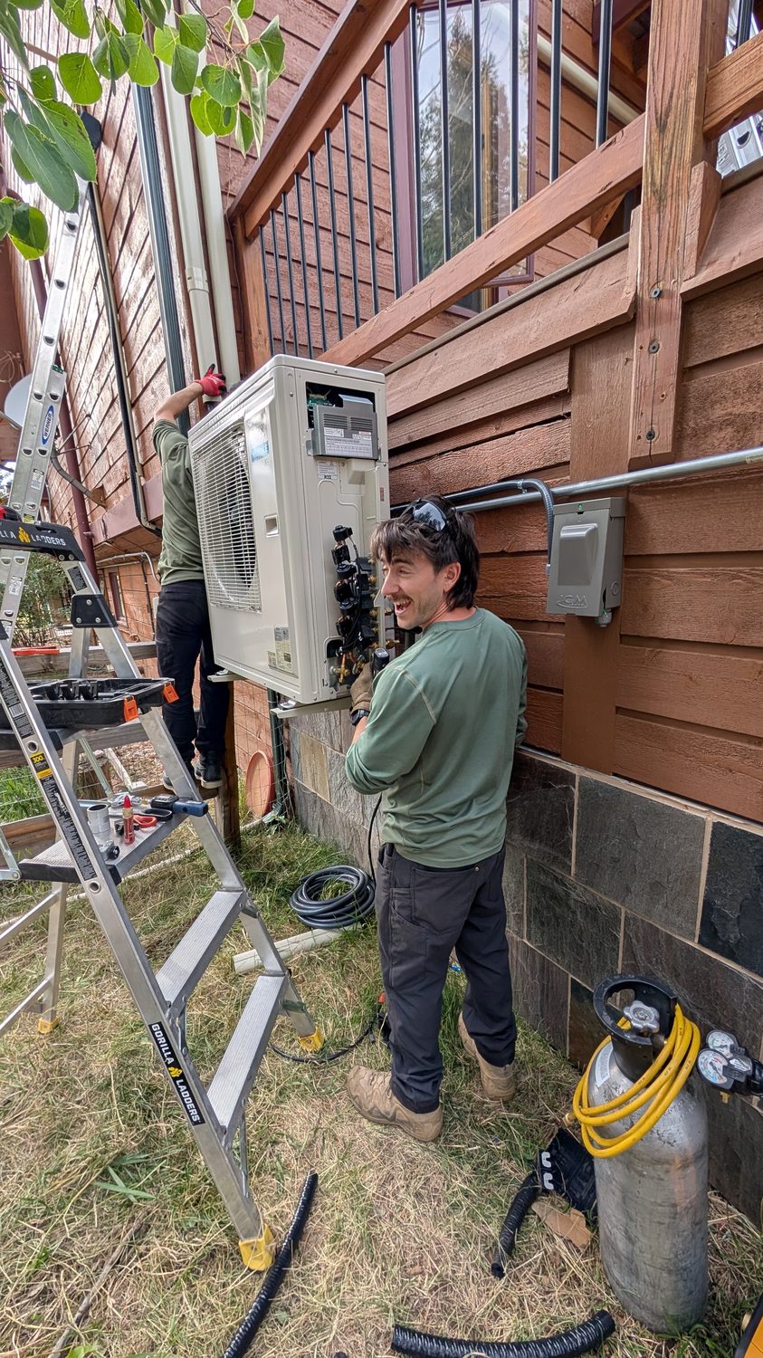 Mini-Splits By Joseph crew installing an outdoor unit from a ladder